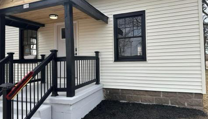 Home renovation by Horizon Exteriors in Wisconsin Rapids and Milwaukee included new white siding, black windows, stair rails and front porch