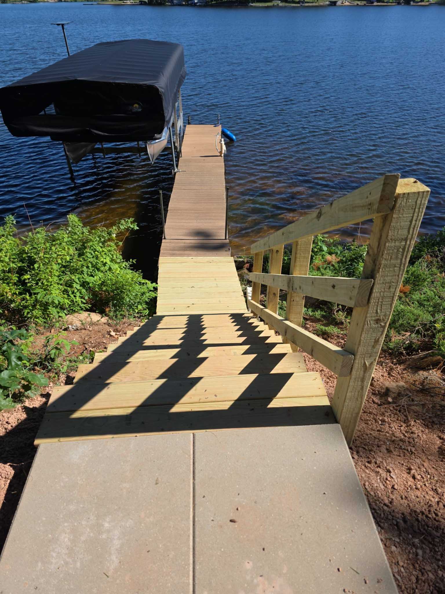 Wooden stairs descend to a lakeside dock—ask a Composite Deck Builder Wisconsin for upgrades.