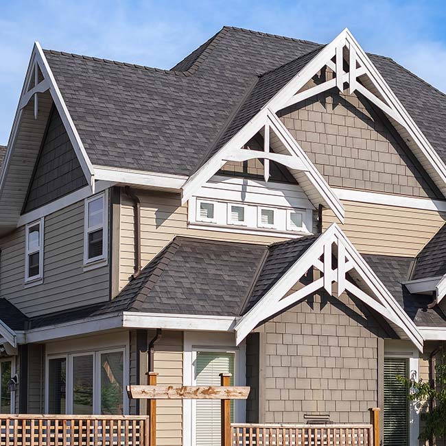 Modern Wisconsin house with gabled roofs, gray siding, white trim, and a spacious deck out back.
